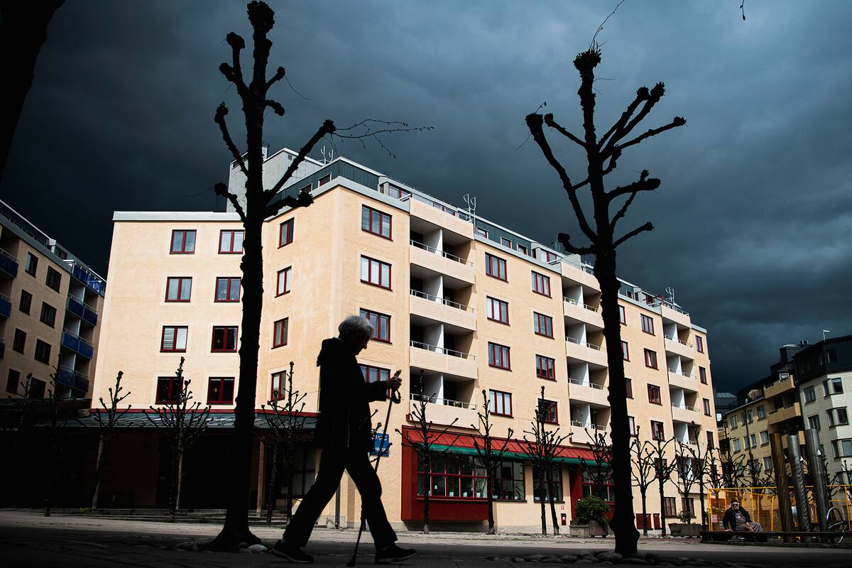 Una mujer camina afuera de un hogar de ancianos en Estocolmo el 4 de mayo de 2020 en plena pandemia de coronavirus