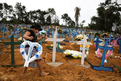 Una mujer camina entre las tumbas, en el cementerio Parque Taruma en Manaus, Brasil