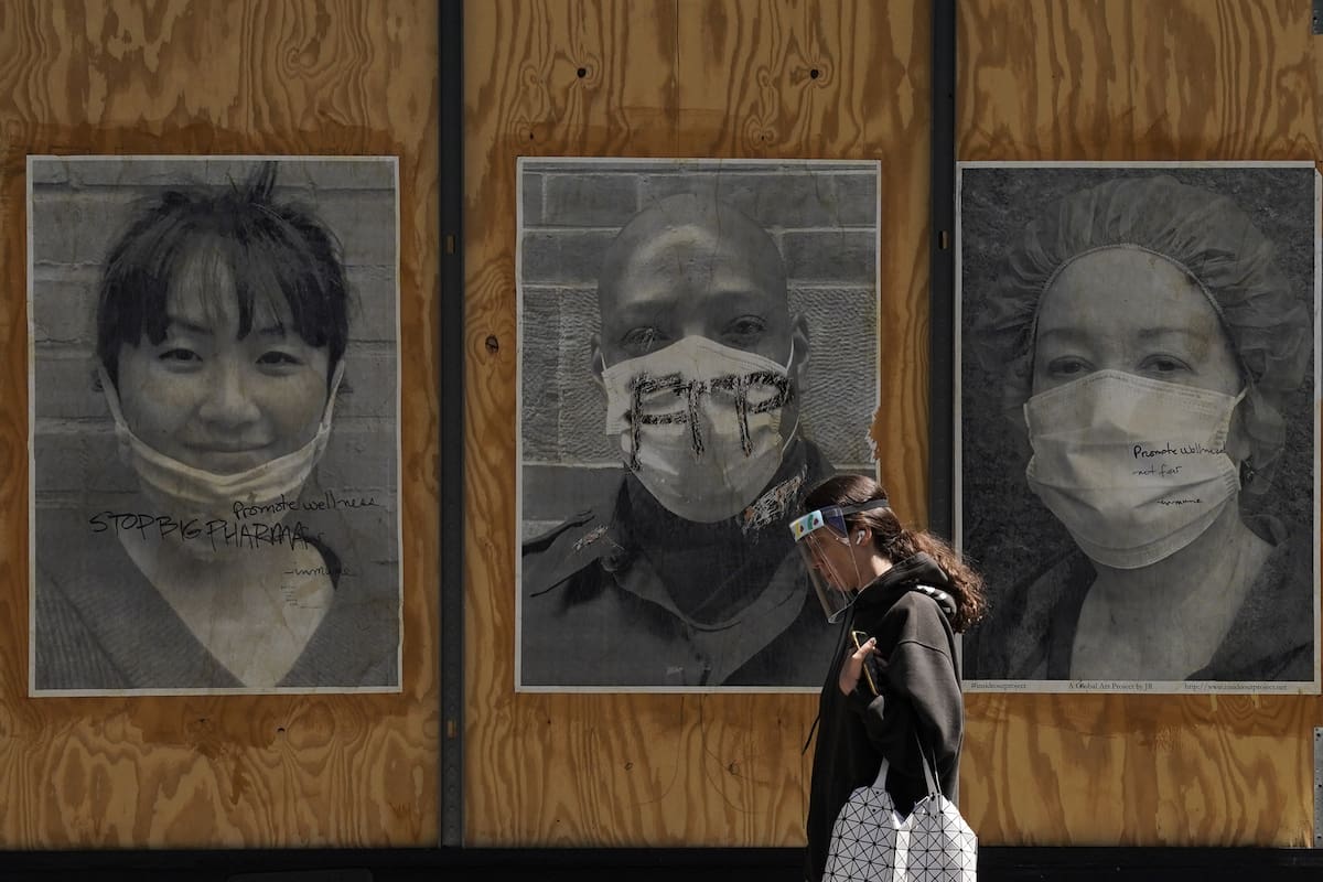 Una mujer camina frente a un proyecto de arte sobre el coronavirus en la ciudad de Nueva York