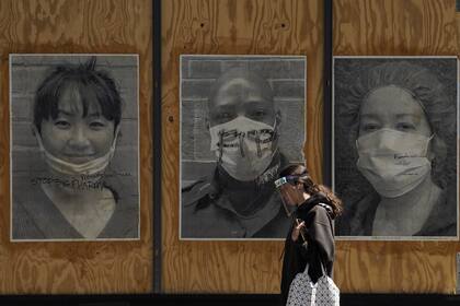 Una mujer camina frente a un proyecto de arte sobre el coronavirus en la ciudad de Nueva York