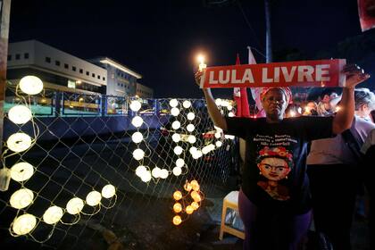 Una mujer coloca un letrero luminoso que reza "Lula libre" afuera de la Superintendencia de la Polícia Federal, en Curitiba