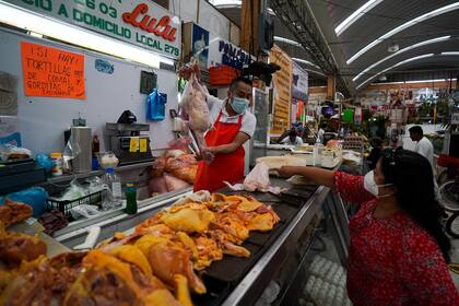 Una mujer compra pollo en un mercado de la Ciudad de México, el martes 9 de agosto de 2022. (AP Foto/Fernando Llano)