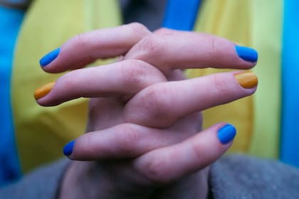 Una mujer con las uñas pintadas con los colores de la bandera ucraniana participa en una protesta contra la escalada de tensiones entre Rusia y Ucrania