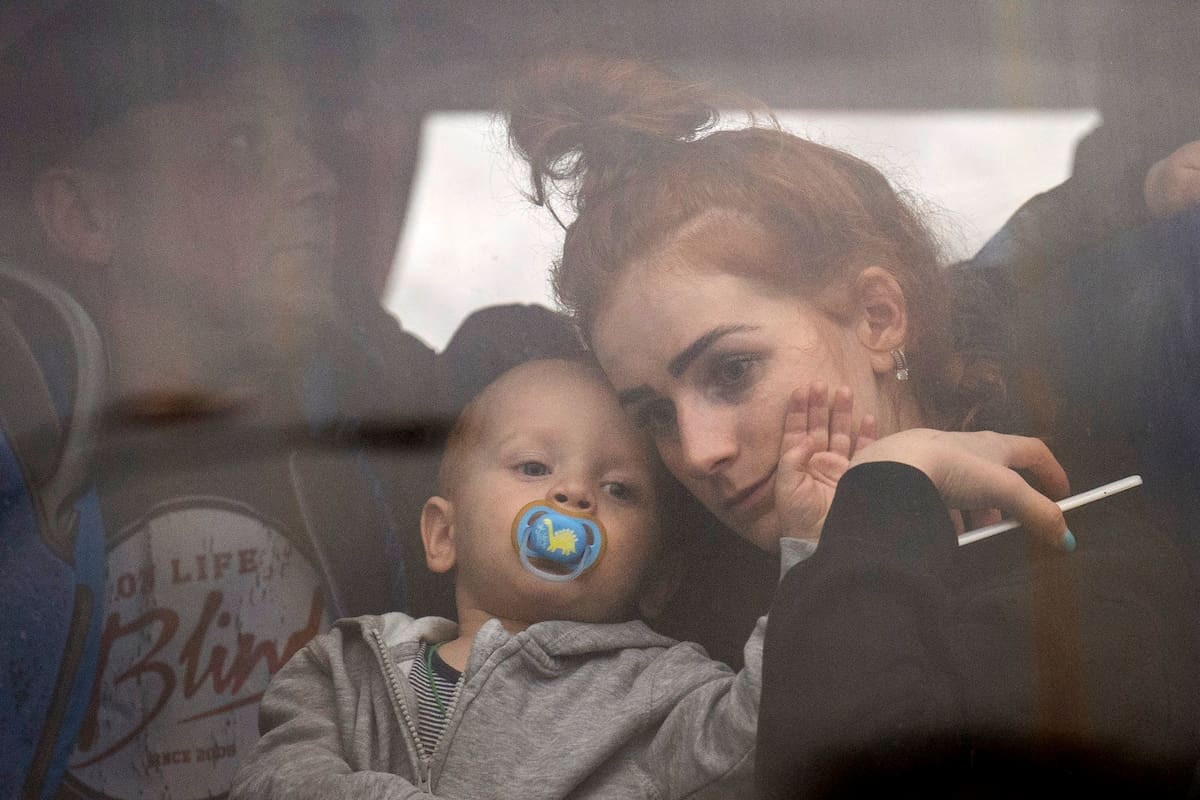 Una mujer, con su hijo en brazos, sentada en un bus antes de abandonar Kiev, Ucrania, el 24 de febrero de 2022