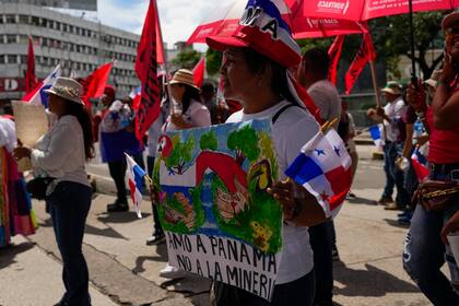 Una mujer con un cartel de rechazo a la minería durante una protesta contra un contrato minero entre el Estado panameño y la compañía minera canadiense First Quantum, en Ciudad de Panamá, el viernes 3 de noviembre de 2023 (AP Foto/Arnulfo Franco)