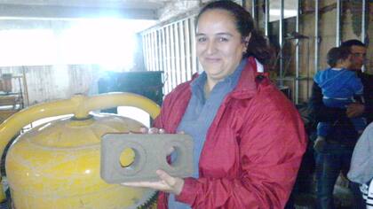 Una mujer con un ladrillo que será la base de su futura casa.