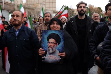 Una mujer con una foto del ayatollah en Teherán tras los ataques