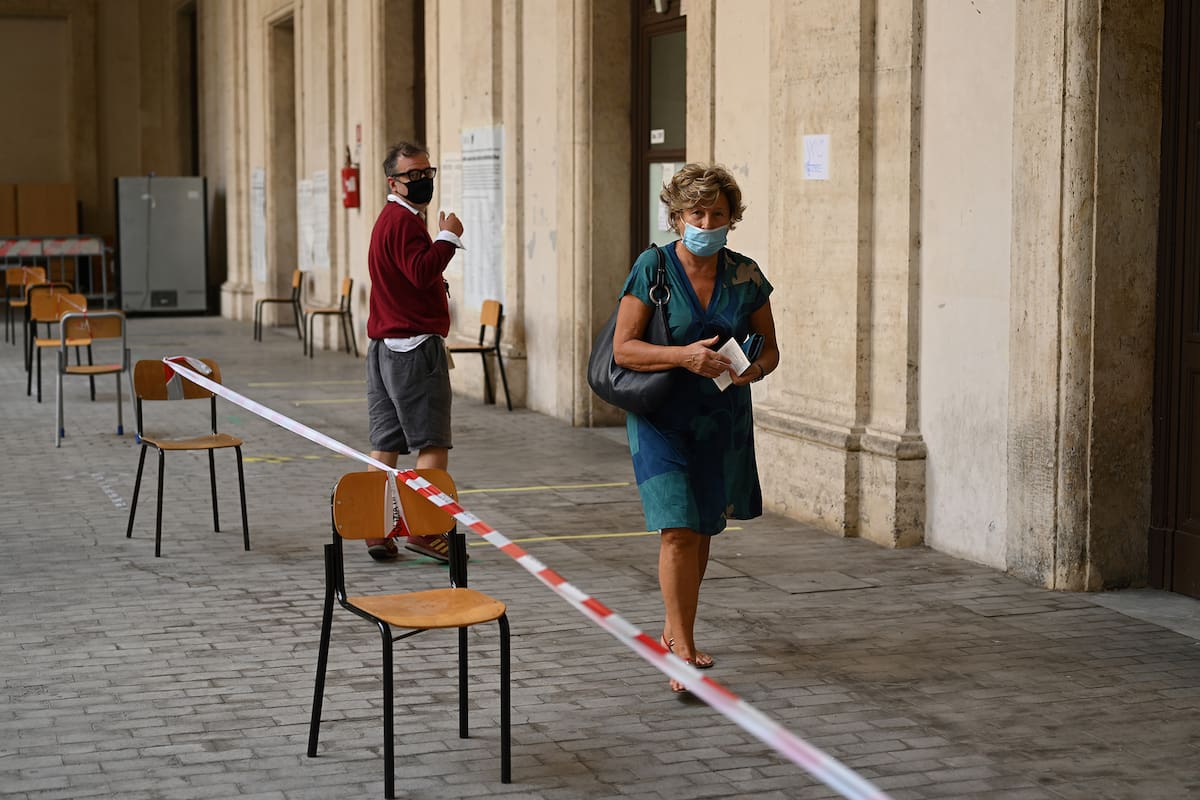 Una mujer con una mascarilla se va después de emitir su voto en un colegio electoral en el centro de Roma el 20 de septiembre de 2020