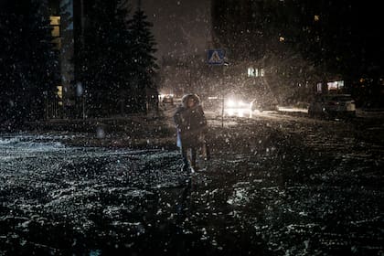 Una mujer cruza la calle durante una nevada, mientras continúan los cortes de energía en Kiev, Ucrania, el viernes 16 de diciembre de 2022. (Foto AP/Felipe Dana, archivo)
