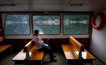 Una mujer da un paseo en el barco fluvial que conecta la estación de tren y el pueblo de HallstattFoto: JOE KLAMAR