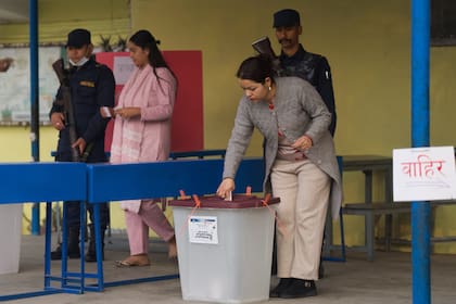 Una mujer deposita su boleta en un centro de votación para las elecciones parlamentarias en Katmandú