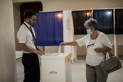 Una mujer deposita su boleta en un centro de votación durante un referéndum sobre el aborto en Gibraltar, el 24 de junio de 2021. (AP Foto/Javier Fergó)
