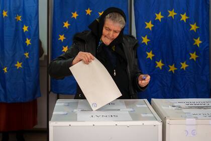 Una mujer deposita sus votos en las elecciones parlamentarias de Rumania, en Baleni, el domingo 1 de diciembre de 2024. (AP Foto/Vadim Ghirda)