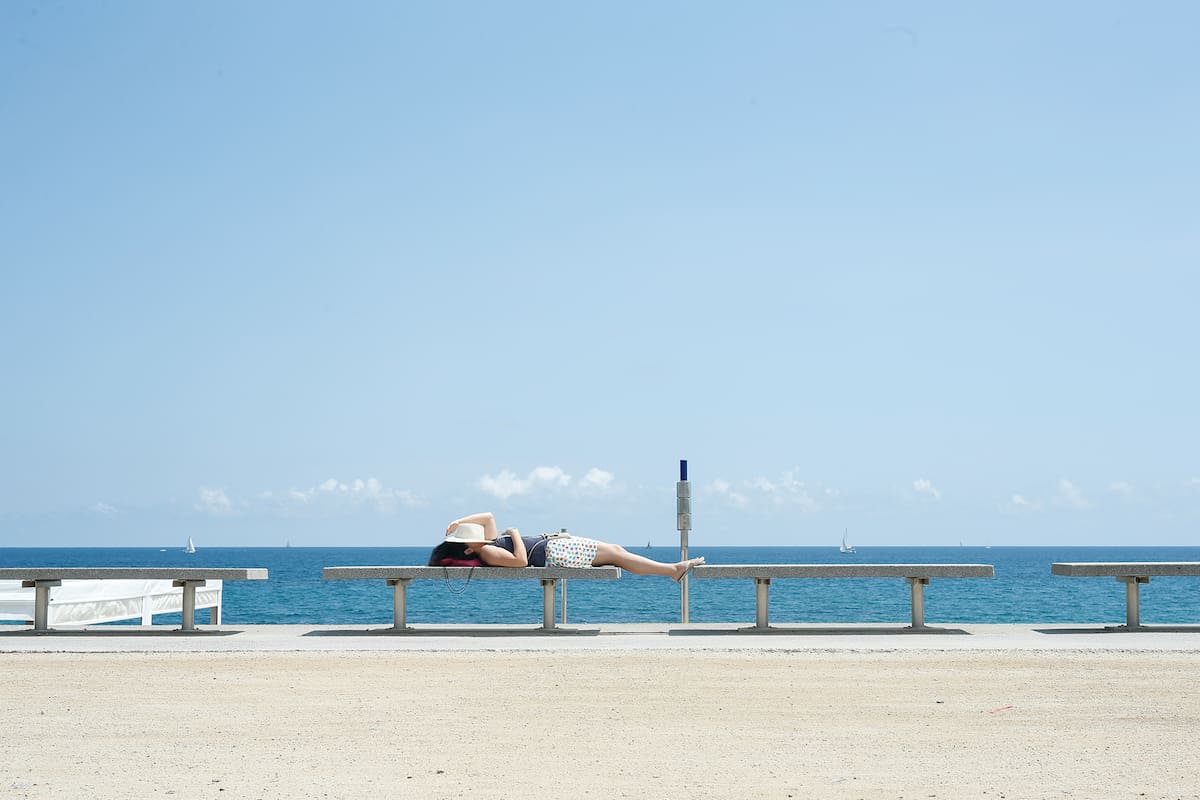 Una mujer descansa en un paseo marítimo de Barcelona el 30 de mayo de 2020 cuando el país comienza a aflojar un bloqueo nacional para evitar la propagación del nuevo coronavirus
