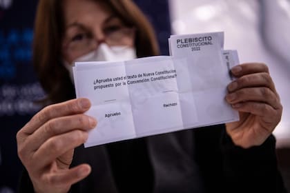 Una mujer en Santiago muestra la papeleta de esta votación