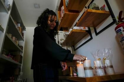 Una mujer enciende velas en su tienda ante los cortes de electricidad programados por el Ministerio de Energía, en Quito, Ecuador, el martes 16 de abril de 2024. Ecuador enfrenta racionamientos de electricidad debido a una prolongada sequía y a las altas temperaturas que han reducido los caudales que abastecen a las principales centrales hidroeléctricas. (AP Foto/Dolores Ochoa)