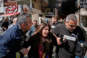 Una mujer es asistida tras un ataque de Israel en Beirut