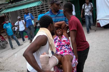 Una mujer es trasladada al hospital Immaculée Conception en Les Cayes, Haití, el 16 de agosto de 2021, dos días después de un sismo de magnitud 7,2 que remeció el suroeste del país. (AP Foto/Matías Delacroix)