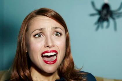 Una mujer grita al ver una araña.