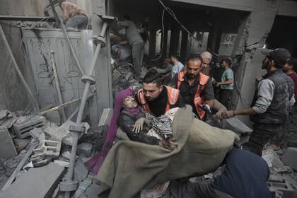 Una mujer herida es rescatada en el campo de refugiados de Khan Yunis, en la Franja de Gaza, tras un ataque israelí. (AP/Mohammed Dahman)