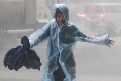 Una mujer intenta huir de los vientos de la tormenta en Shenzhen