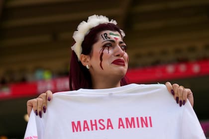 Una mujer iraní entró al campo de juego para protestar con una remera de la joven de 22 años que murió tras ser detenida por la policia de la moral (AP Photo/Alessandra Tarantino)