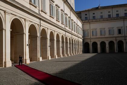 Una mujer limpia una alfombra que conduce a la oficina del presidente italiano, Sergio Mattarella, en el Palacio Presidencial del Quirinale, en Roma, Italia, el 20 de octubre de 2022. (Foto AP/Gregorio Borgia)