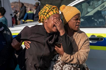 Una mujer llora en la escena de un tiroteo nocturno en un bar en Soweto, Sudáfrica, el domingo 10 de julio de 2022. (Foto AP/Shiraaz Mohamed)