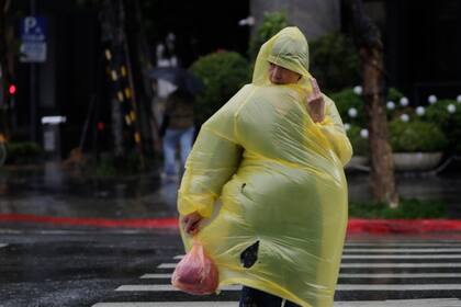 Una mujer lucha con el viento y la lluvia del tifón Kong-rey en Taipéi, Taiwán, el jueves 31 de octubre de 2024. (AP Foto/Chiang Ying-ying)