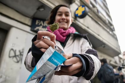 Una mujer muestra un paquete de marihuana comprado en una farmacia en Uruguay