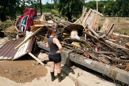 Una mujer observa los escombros en un puente de la ciudad de Waverly, Tennessee, el domingo 22 de agosto de 2021. (AP Foto/Mark Humphrey)