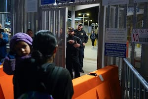 Una mujer originaria de Guatemala carga a su hija mientras pregunta a agentes de la Oficina de Aduanas y Protección Fronteriza de Estados Unidos sobre las nuevas reglas de asilo en el Puerto de Entrada de San Ysidro, el 11 de mayo de 2023, desde Tijuana, México (AP Foto/Gregory Bull, Archivo)