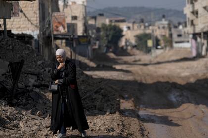 Una mujer palestina camina por una carretera destruida tras una redada del Ejército israelí en el campo de refugiados de Yenín, Cisjordania, el 2 de febrero de 2025