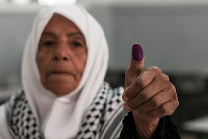 Una mujer palestina muestra su pulgar luego de ejercer el sufragio