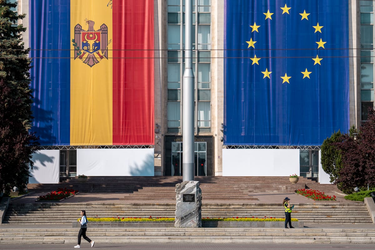 Una mujer pasa junto a un edificio gubernamental decorado con banderas de Moldavia y la Unión Europea en Chisinau