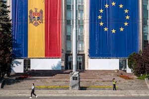 Una mujer pasa junto a un edificio gubernamental decorado con banderas de Moldavia y la Unión Europea en Chisinau, Moldavia, el 31 de mayo de 2023.