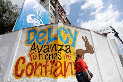 Una mujer pasa junto a un mural en apoyo a la presidenta interina de Venezuela, Delcy Rodríguez, en Caracas