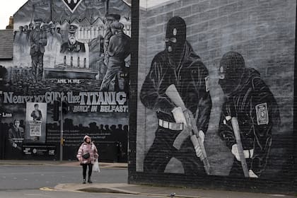 Una mujer pasa junto a un mural paramilitar lealista en Newtownards, Belfast, en enero de 2021