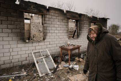 Una mujer pasa junto a una casa destrozada durante la ocupación rusa de su aldea, Andriivka, Ucrania, el 5 de abril de 2022. (AP Foto/Vadim Ghirda)