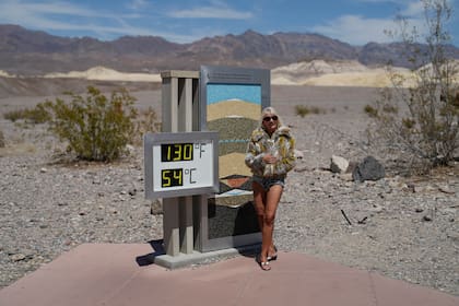 Una mujer posa junto a un termómetro el domingo 16 de julio de 2023, en el Parque Nacional del Valle de la Muerte, California. (AP Foto/John Locher, archivo)