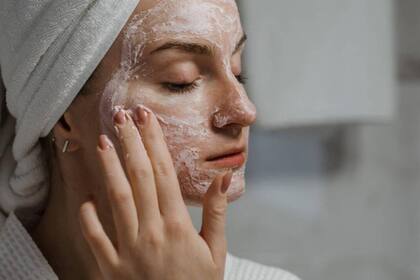 Una mujer se aplica crema en su rostro