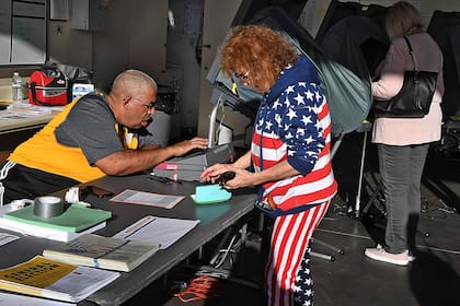 Una mujer se prepara para votar en un centro de votación del Condado de Orange durante las elecciones de 2020 en Huntington Beach, California