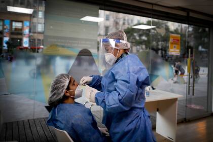 Una mujer se realiza un hisopado, durante la cuarentena en Buenos Aires (AP Photo: Natacha Pisarenko)