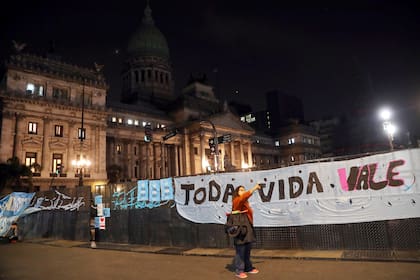 Una mujer se toma una selfie con el cartel a favor de las dos vidas de fondo en la puerta del Congreso de la Nación