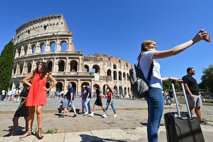 Una mujer se toma una selfie frente al emblemático Coliseo de Roma