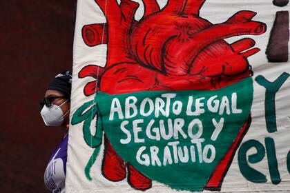Una mujer sostiene un cartel en defensa del aborto mientras manifestantes protestan frente al Congreso Nacional en el "Día por la Despenalización del Aborto en América Latina y el Caribe", en Ciudad de México, el 28 de septiembre de 2020 (AP Foto/Rebecca Blackwell, Archivo)