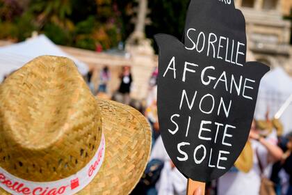 Una mujer sostiene un letrero que dice en italiano "Hermanas afganas, no están solas", durante una manifestación a favor de los derechos de las hermanas afganas en Roma, el sábado 25 de septiembre de 2021. (AP Photo/Andrew Medichini)
