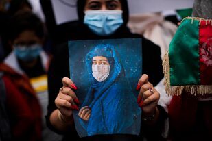 Una mujer sostiene una fotografía durante una protesta para crear conciencia de la situación en Afganistán afuera de la sede de la Unión Europea en Bruselas, el miércoles 18 de agosto de 2021