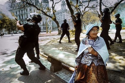 Una mujer sostiene una imagen de Eva Perón durante los enfrentamientos entre manifestantes y la policía, el 20 de diciembre de 2001, en Plaza de Mayo