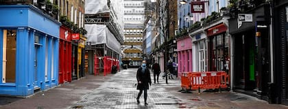 Una mujer usa un barbijo mientras camina en una calle desierta de Carnaby Street, en Londres. La variante británica del virus es una de las más extendidas en Europa.